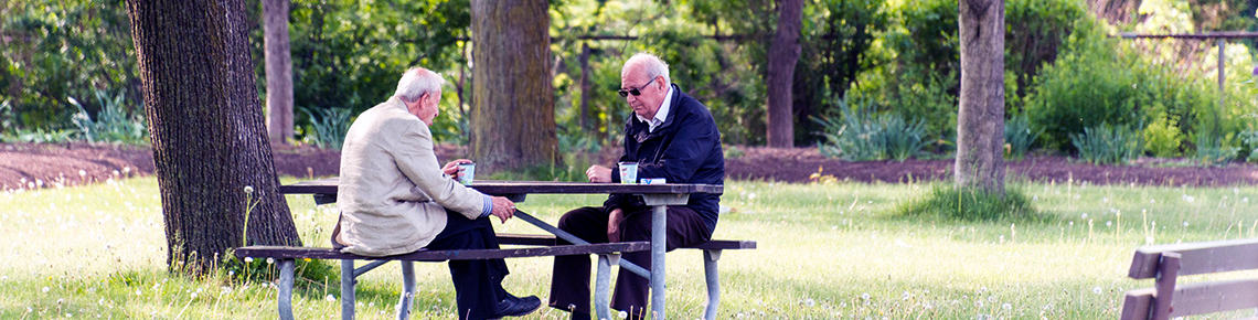 two men at picnic table in park
